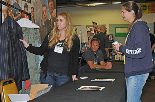 Cryptozoic's Miranda Charsky show off Nathan Fillion's coat to a collector